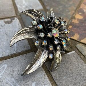 Gold rhinestone brooch with Center stones and stones surrounding.